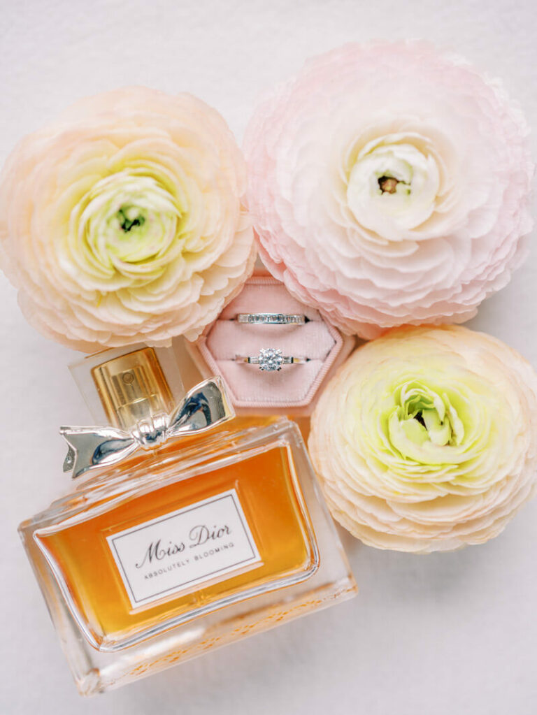 Photo flatlays des alliances, du parfum et des fleurs prise par le photographe de mariage à Toulouse Fabrice Joubert.